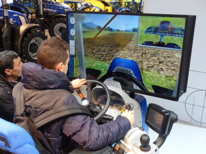 Simulateur de conduite chez New Holland, au travail avec le jeu Farming simulator.