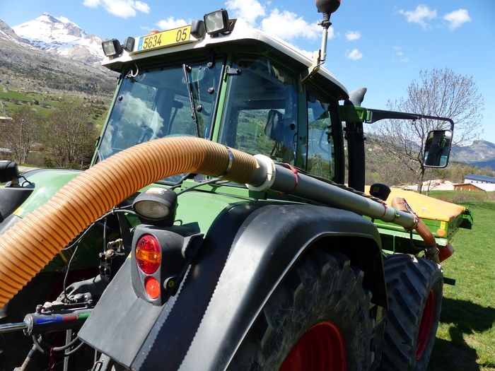 Le mélange de semence et d'engrais est transporté par un flux d'air dans le tube sur le côté du tracteur.