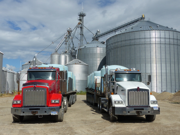 Deux camions de transport appartenant à la ferme garés devant l’un des deux sites de stockage.